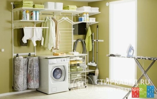 Удачное решение – размещение стиральной машины в подсобном помещении рядом с системой хранения, сушилкой и гладильной доской